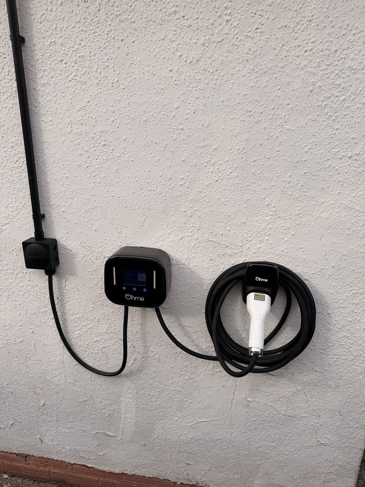 EV charge point installed by Bris Electrical on an exterior wall in Monmouth